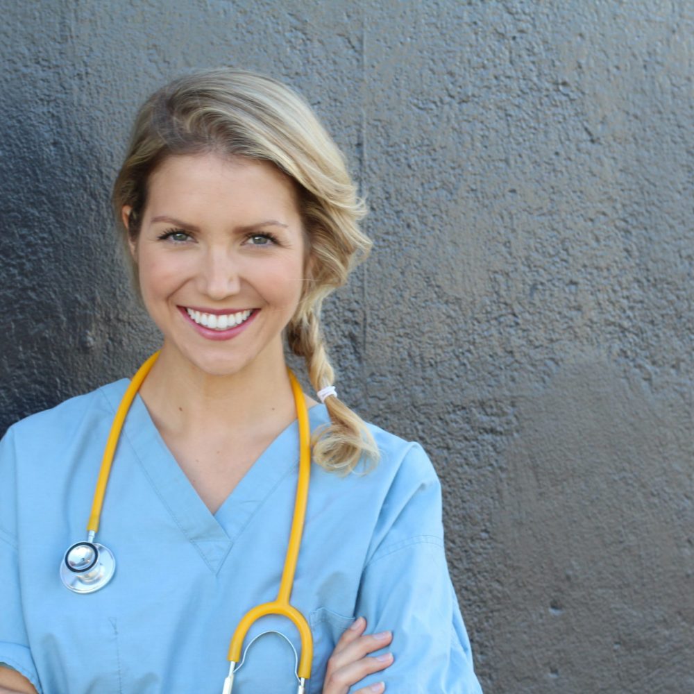 Beautiful young doctor with stethoscope and copy space for text