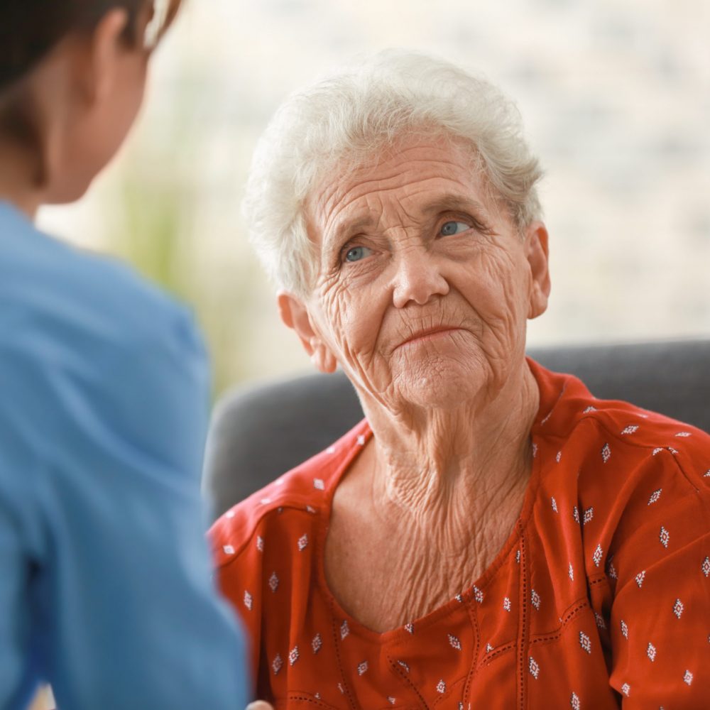 Young nurse visiting elderly woman at home