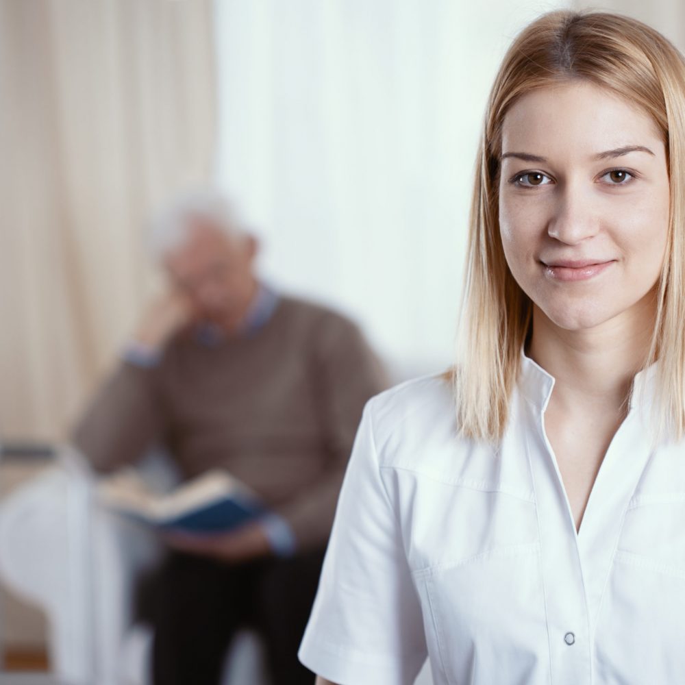 Beautiful young nurse with blonde hair and white uniform